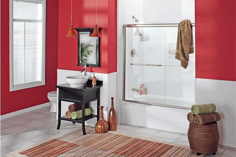 A bathroom featuring vibrant red walls complemented by classic white tile accents.