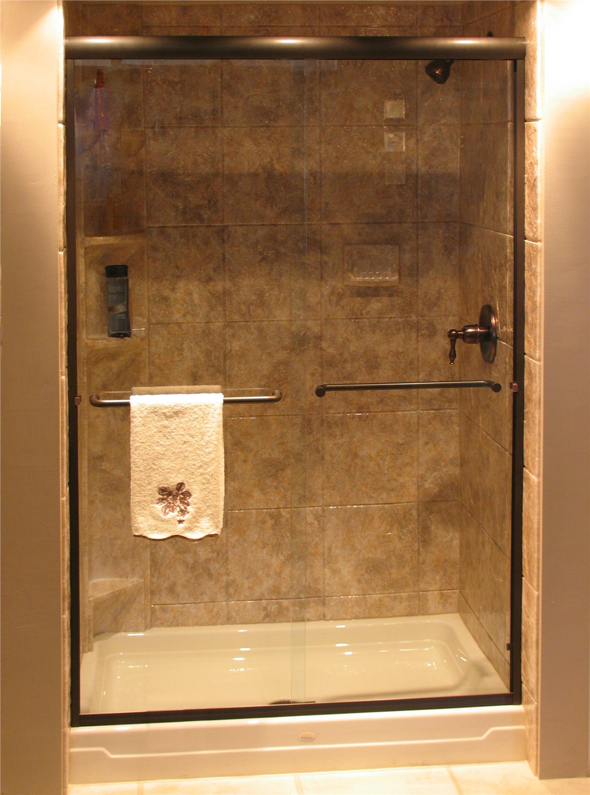 A glass shower door with a neatly folded towel resting on top.