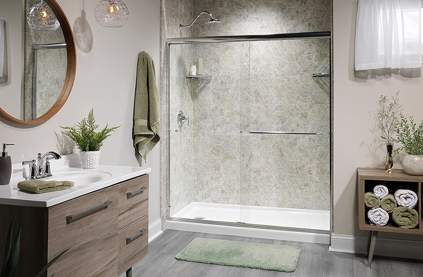 A bathroom featuring a shower, sink, and toilet, with neutral-colored tiles and modern fixtures.