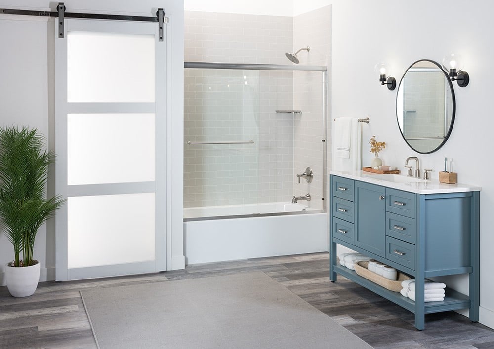 A bathroom featuring a blue vanity and a rustic sliding barn door.